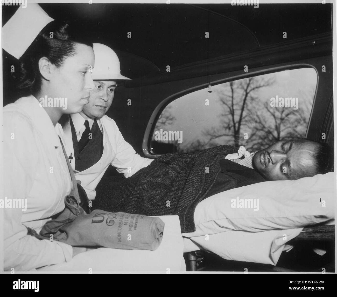 After receiving first aid treatment in practice raid in Washington, DC, air-raid `victim' is removed to hospital by a Medical Corps of the Office of Civilian Defense. The physician is Dr. Charles Drew, ca. 1941 - ca. 1945 Stock Photo